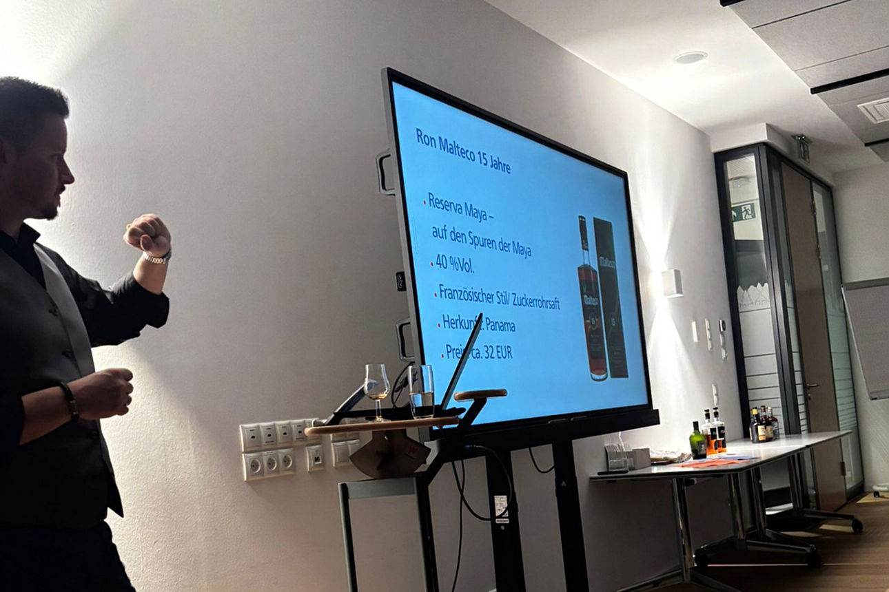 Ein Mann steht vor einem Bildschirm mit einer Präsentation