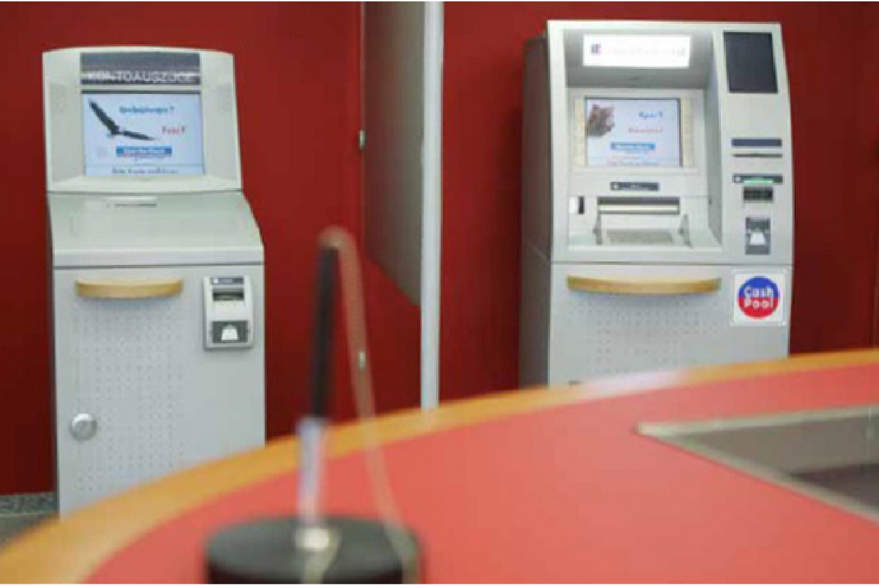 Geldautomat und Kontoauszugsdrucker vor roter Wand