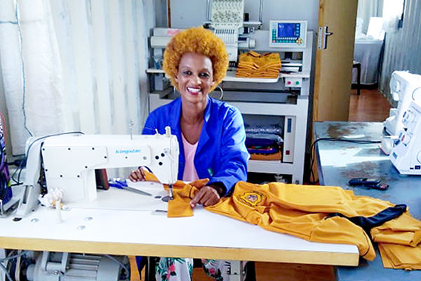 Eine Schneiderin in Südafrika näht eine Schuluniform