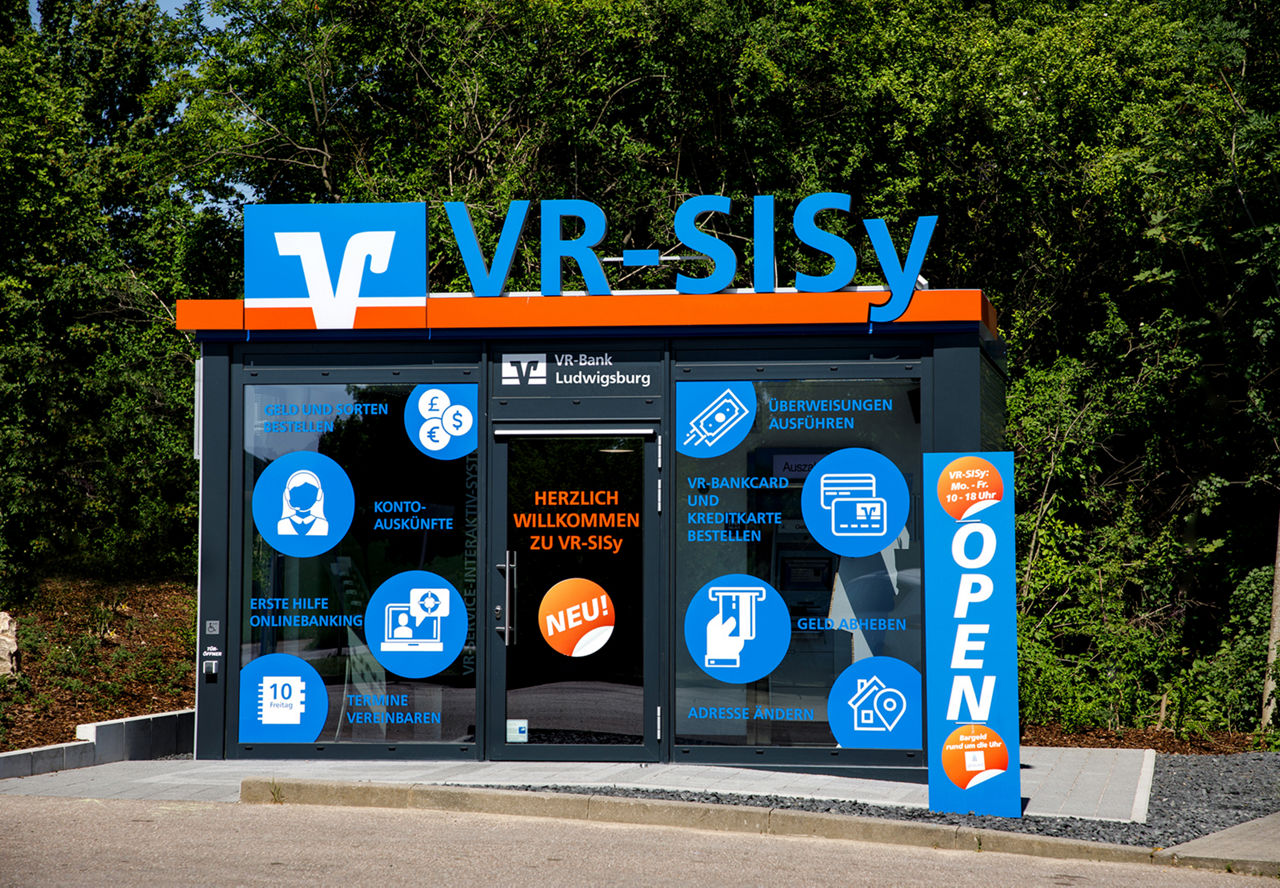 Modernes VR-SISy-Servicegebäude der VR-Bank Ludwigsburg mit blauer Glasfassade und Symbolen.