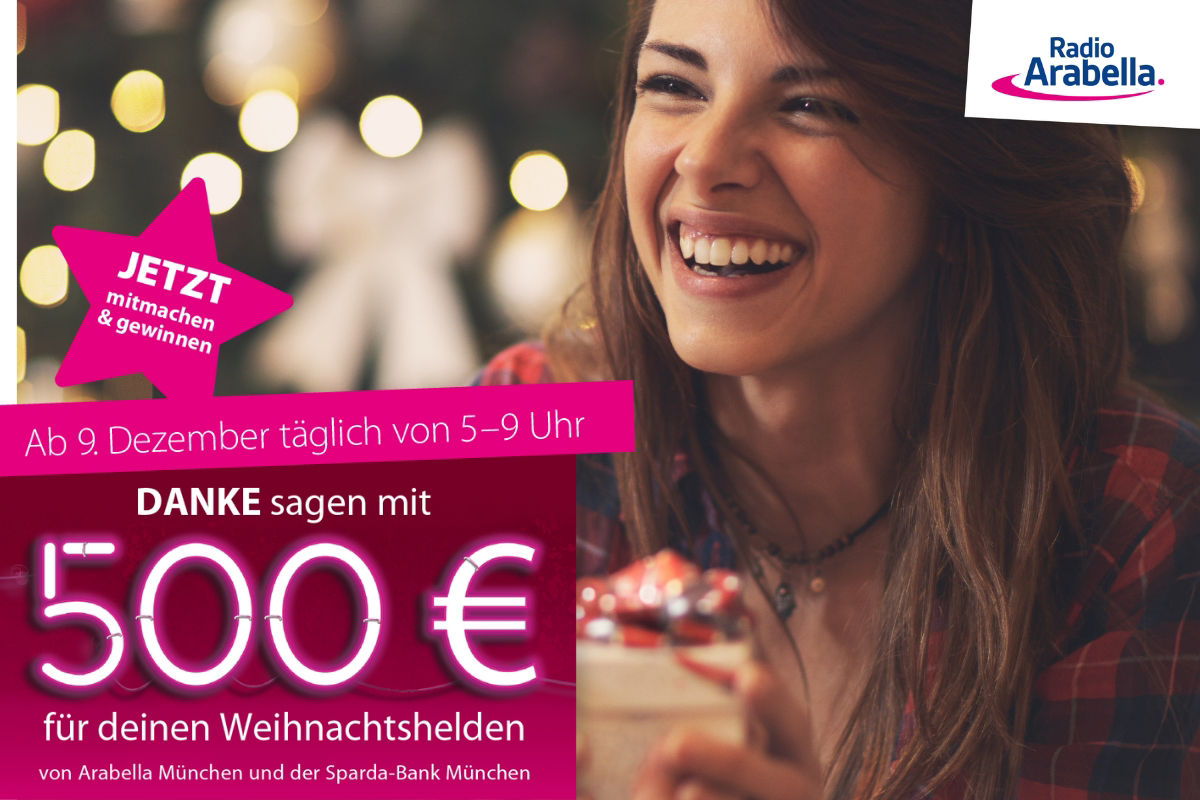 Lächelnde Frau mit braunen Haaren freut sich in einer Weihnachtskulisse.