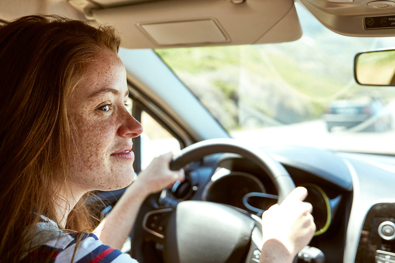Eine Jugendliche sitzt am Steuer eines Autos