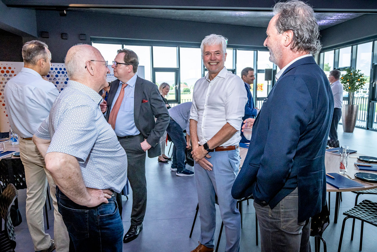 Gesellige Runde - Herren im Gespräch miteinander in Businesskleidung