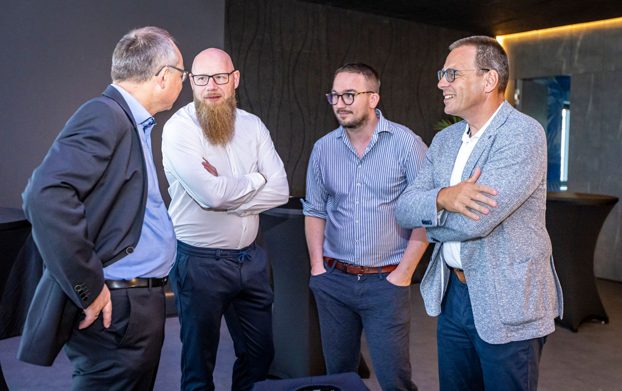 Gesellige Runde - Herren im Gespräch miteinander in Businesskleidung