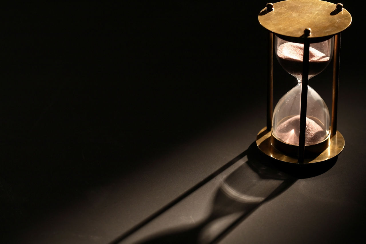 laufende Sanduhr auf schwarzem Hintergrund