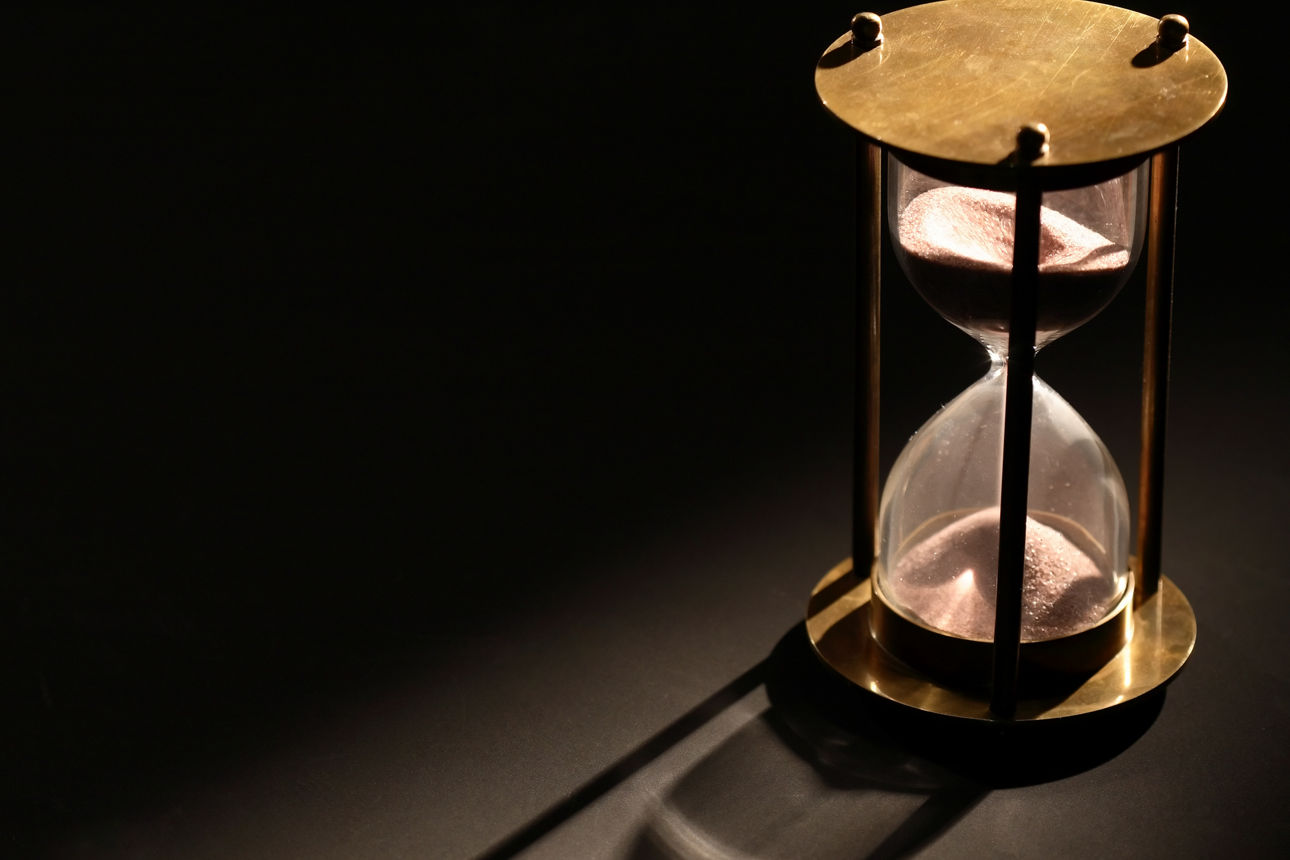 laufende Sanduhr auf schwarzem Hintergrund