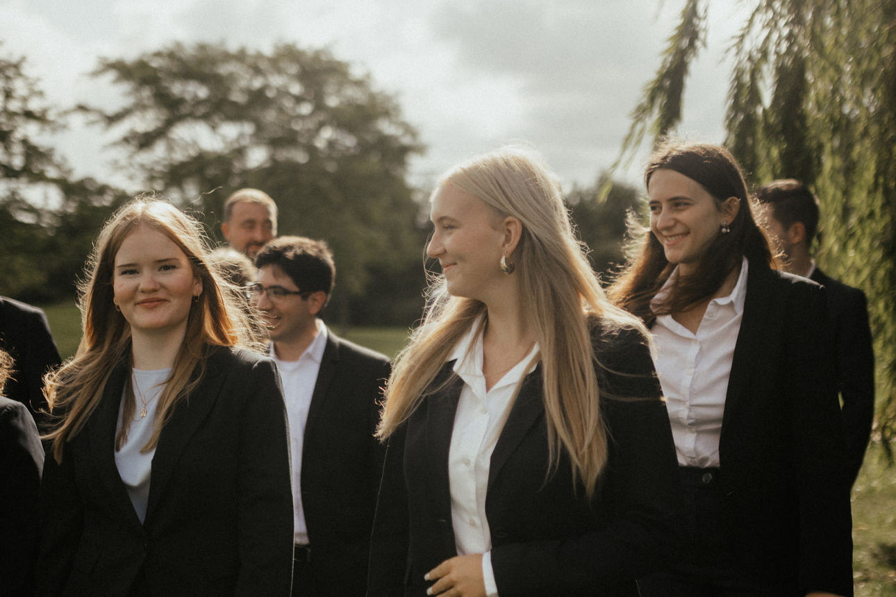 Eine Gruppe junger Erwachsener läuft über eine Wiese