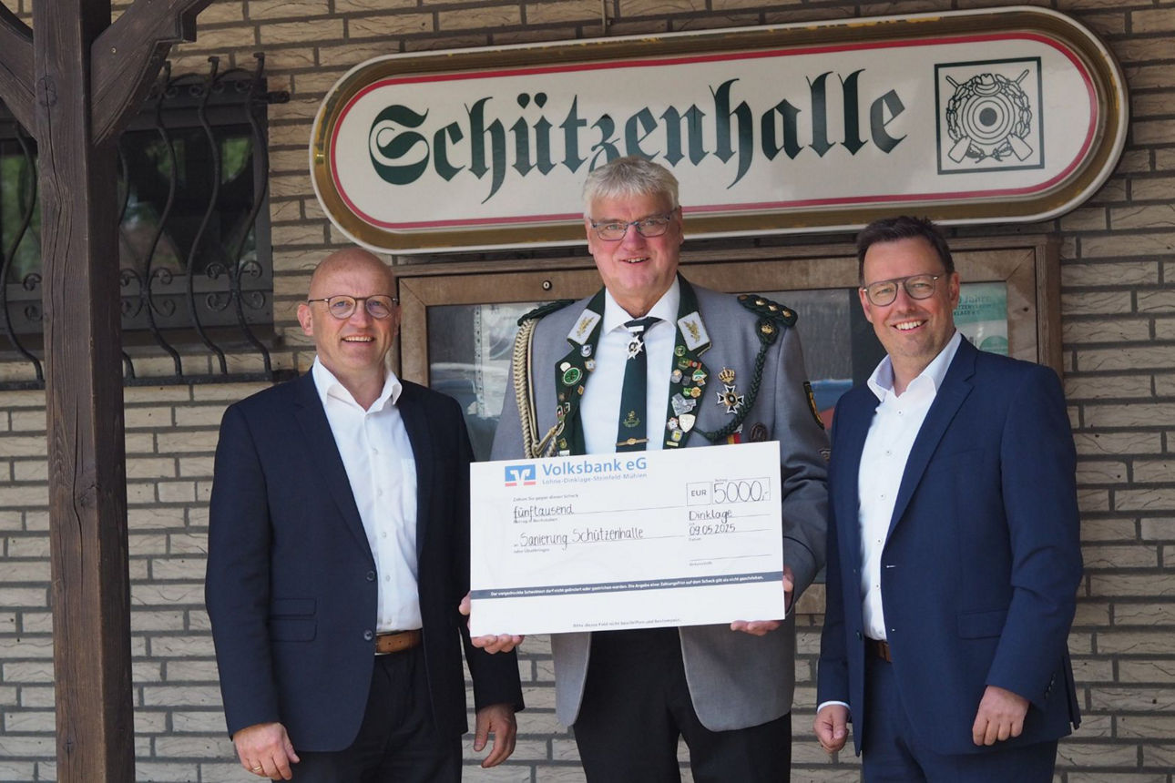 Drei Männer halten einen großen Scheck 