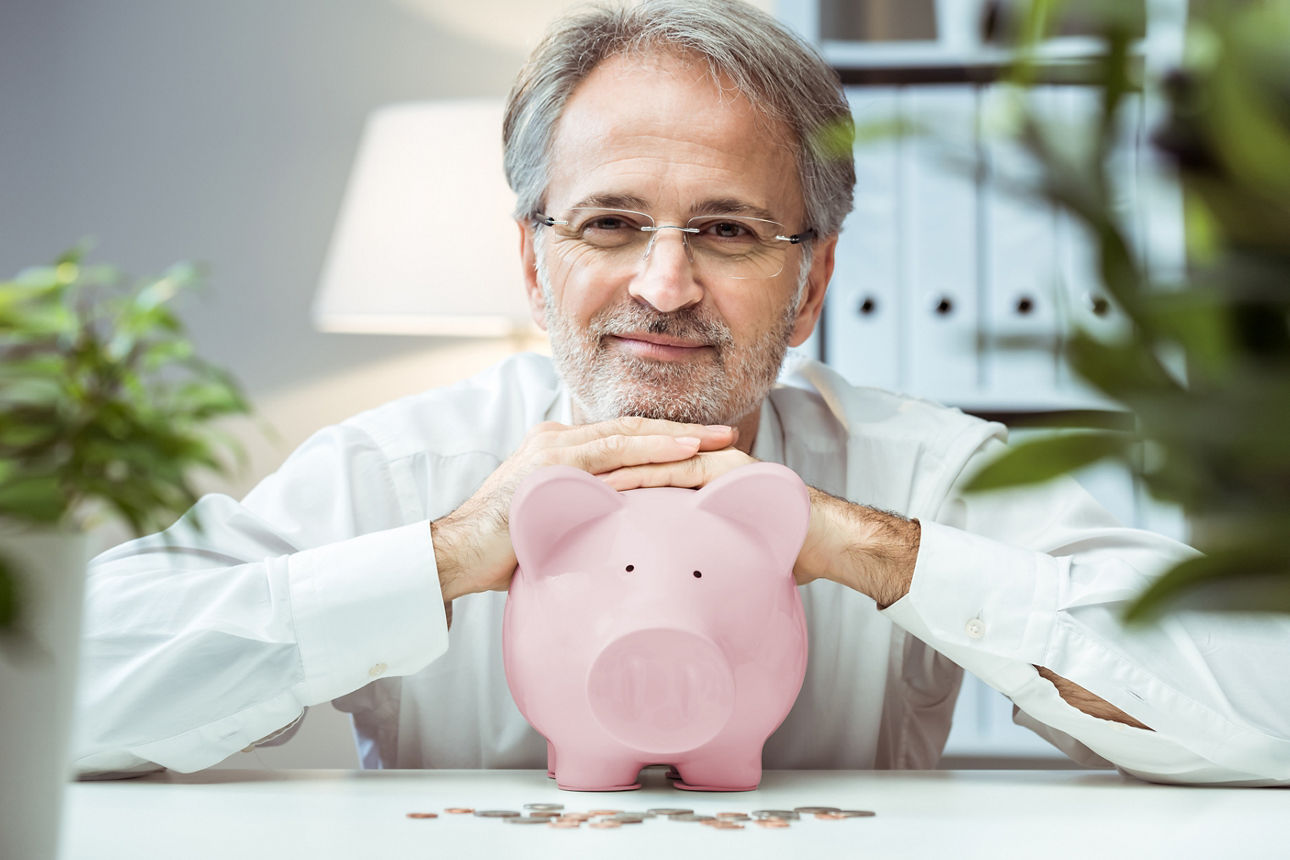Erwachsener Mann mit Sparschwein. Konzept des verantwortungsvollen Investierens.