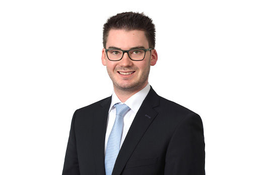 Freundlich lächelnder Mann im Anzug, unser Privatkundenberater Raphael Schaumeier