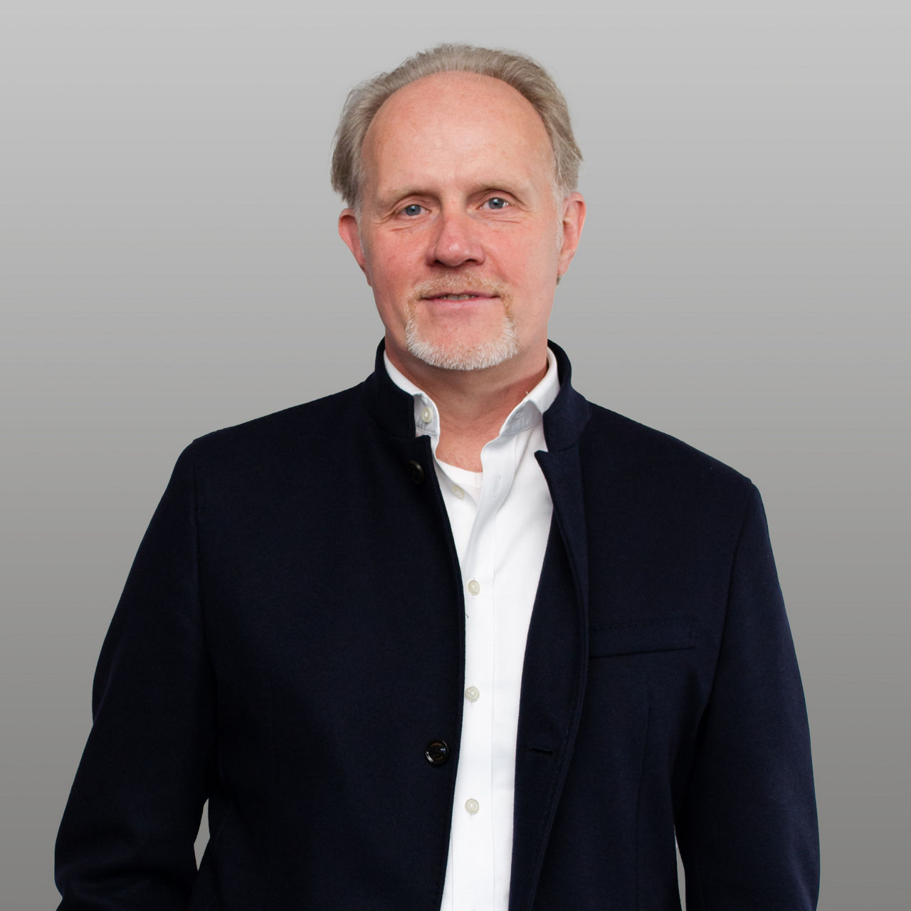 R+V Versicherung Firmenkundenberater Vorsorge Stefan Schell vor grauem Hintergrund