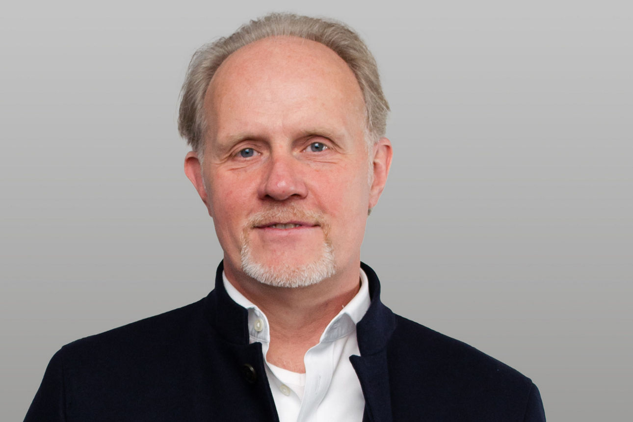 R+V Versicherung Firmenkundenberater Vorsorge Stefan Schell vor grauem Hintergrund