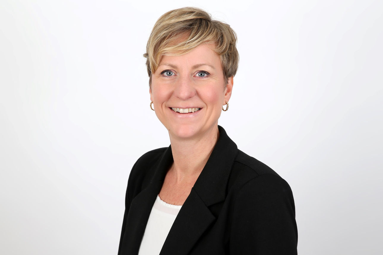 Eine lächelnde Frau schaut in die Kamera.