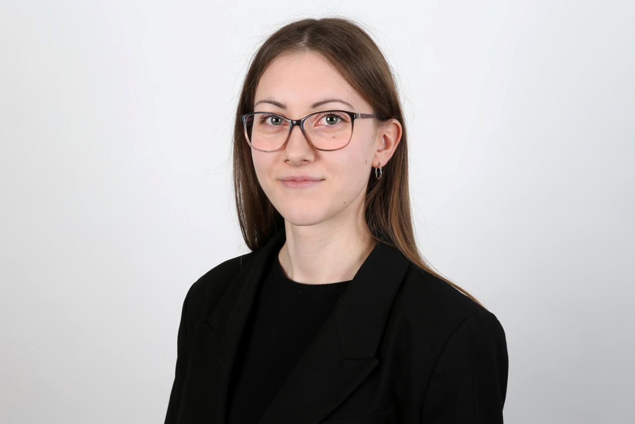 Eine lächelnder Frau schaut in die Kamera.