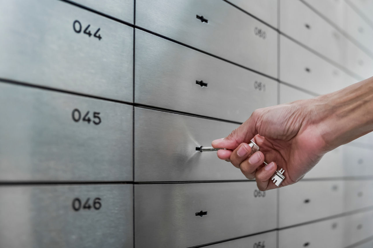 Hand öffnet Schließfach mit Schlüssel