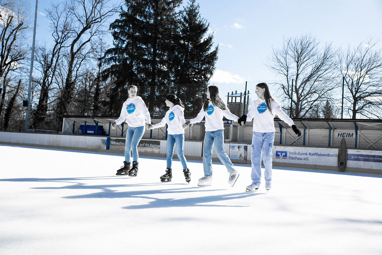 Vier Mädchen fahren Schlittschuh