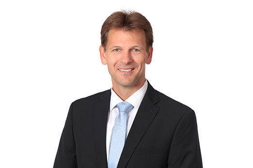 Freundlich lächelnder Mann im Anzug, unser Abteilungsleiter Unternehmensservice Martin Schmidt
