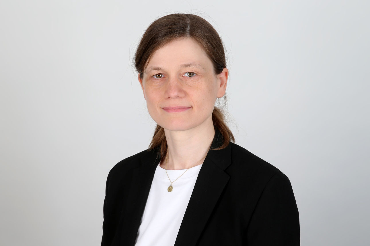 Eine lächelnde Frau schaut in die Kamera.