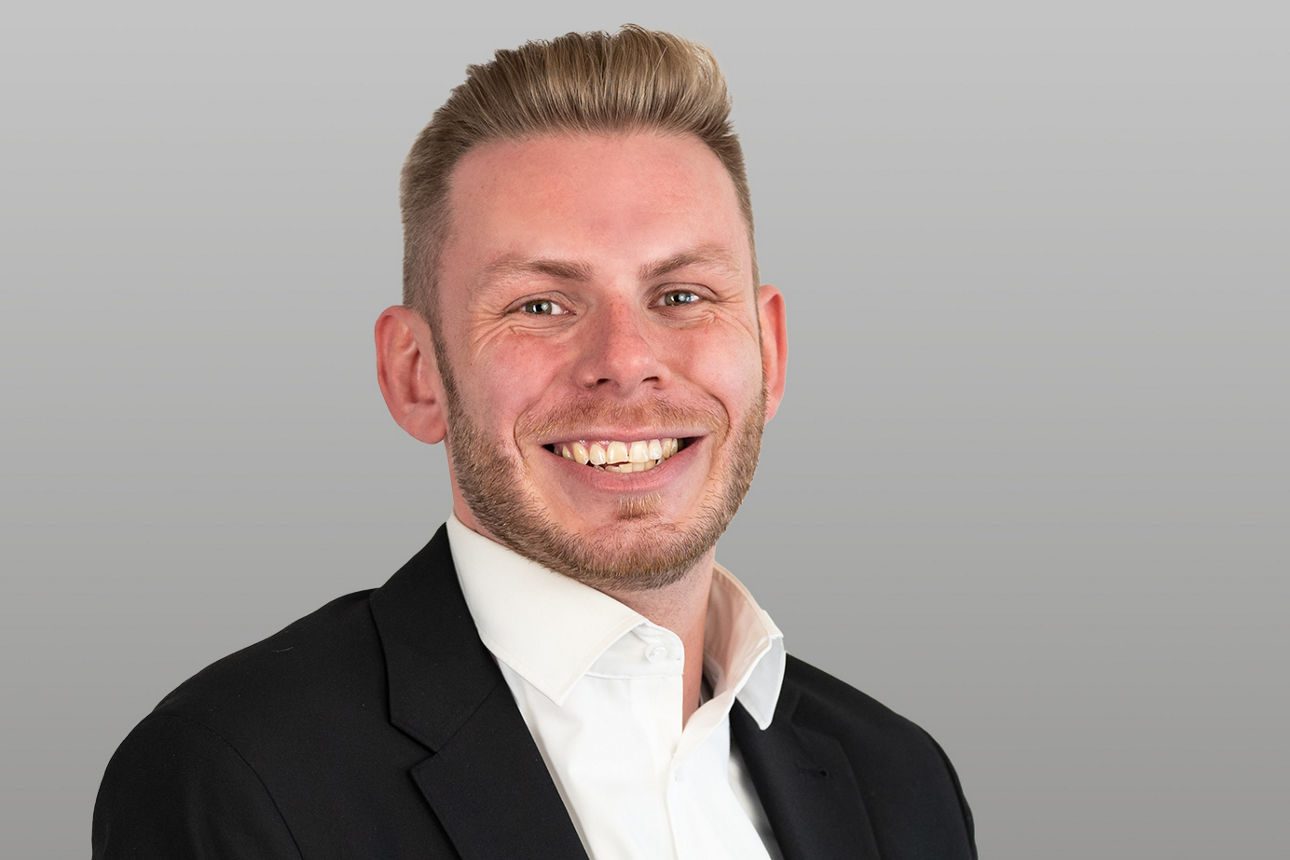 Privatkundenberater  Jan Schmitt vor grauen Hintergrund