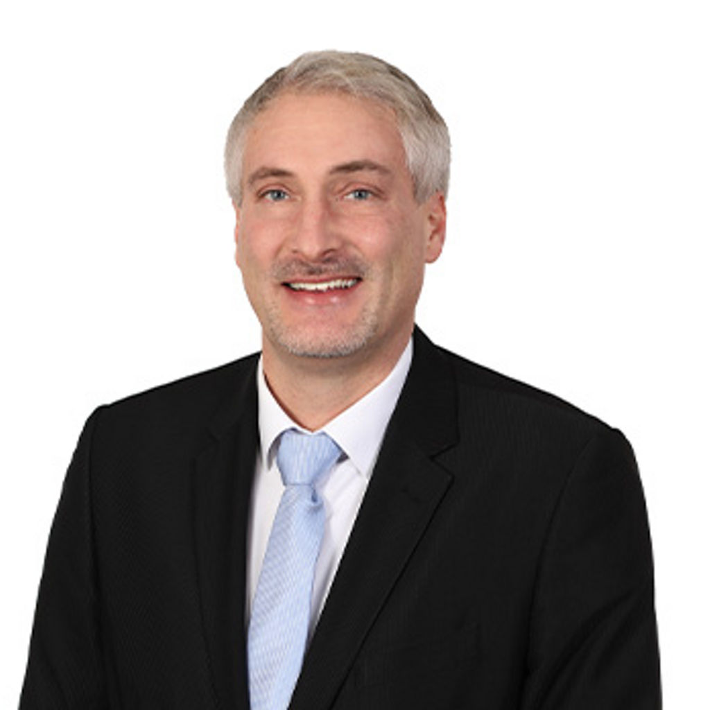Freundlich lächelnder Mann im Anzug, unser Versicherungsreferent Versicherungsreferent Simon Schneider