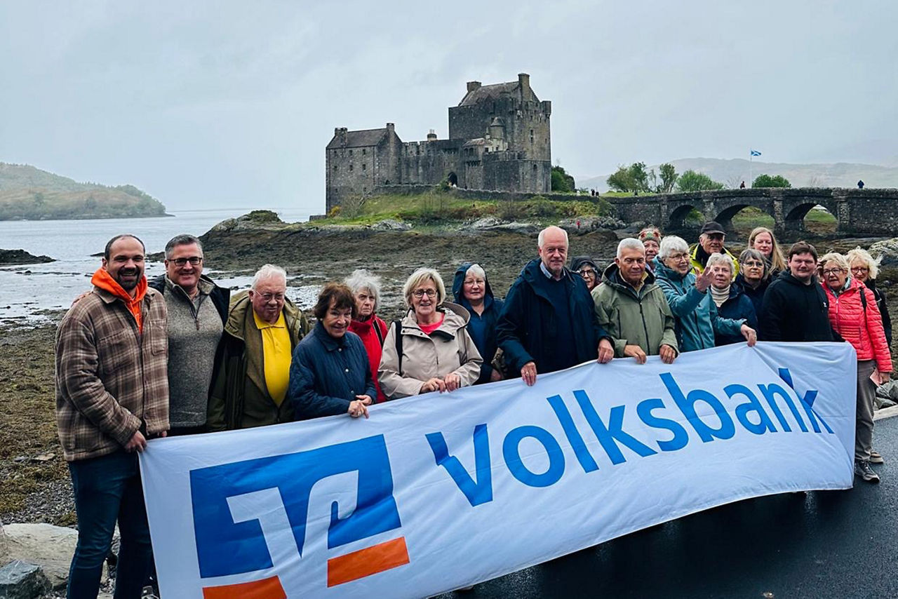 Volksbank Schermbeck - Sonderreise Schottland - Mitreisende mit Banner der Volksbank Schermbeck