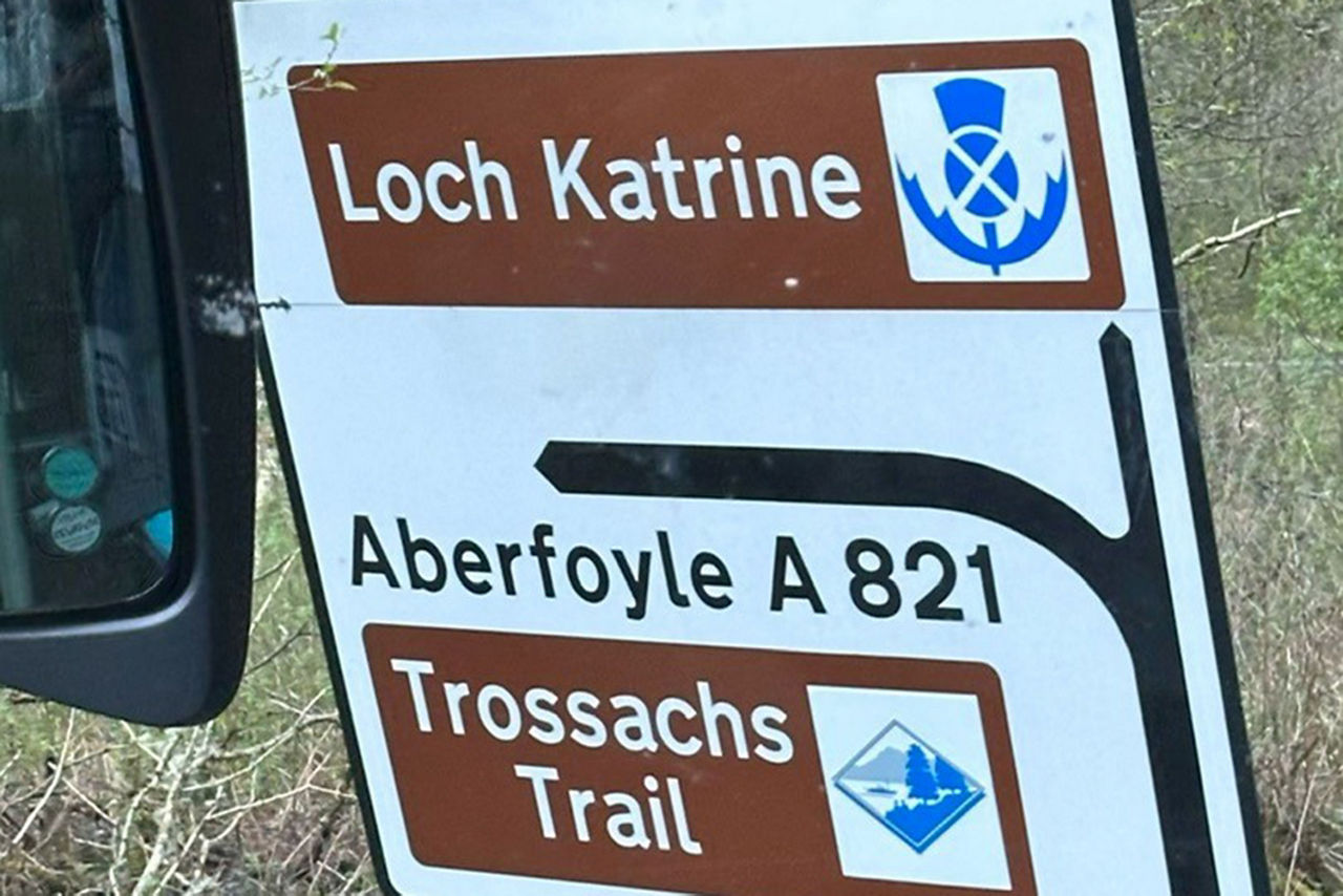 Straßenschild mit der Aufschrift "Loch Katrine" und "Aberfoyle A 821" sowie "Trossachs Trail"