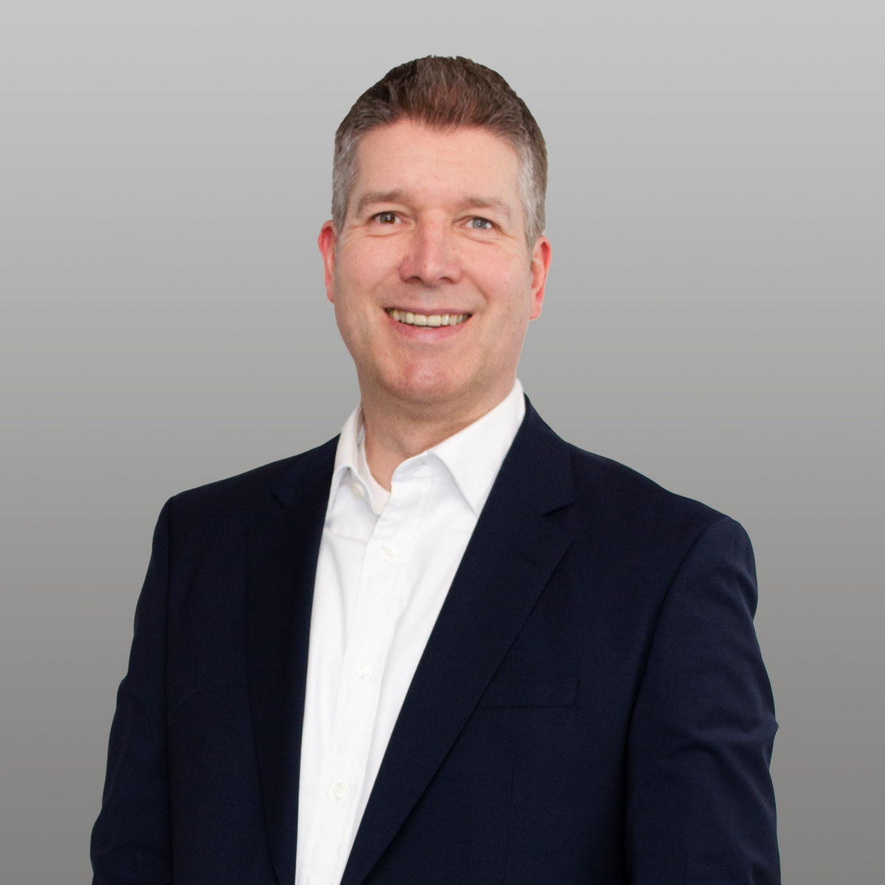 R+V Versicherung Unternehmenskundenberater Komposit Marc Schrandt vor grauem Hintergrund