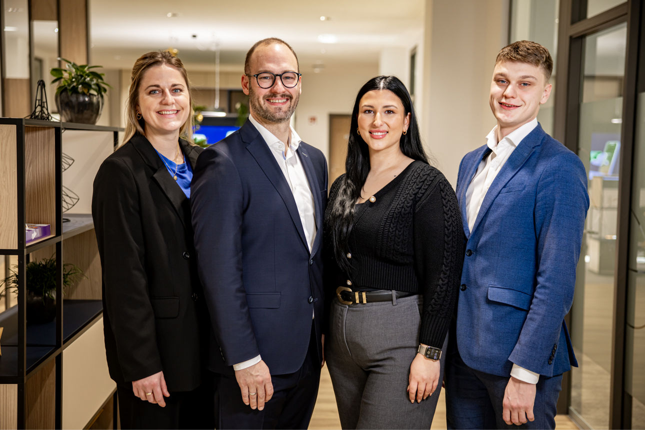Das Team posiert gemeinsam im Büro.