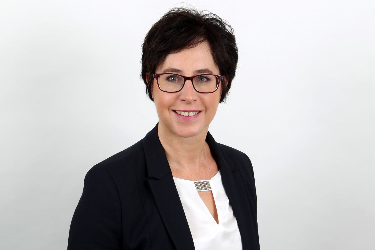 Eine lächelnde Frau schaut in die Kamera.