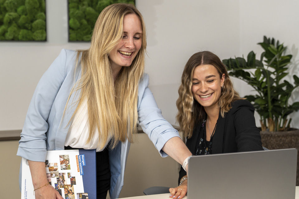 Zwei Frauen schauen gemeinsam auf einen Laptop