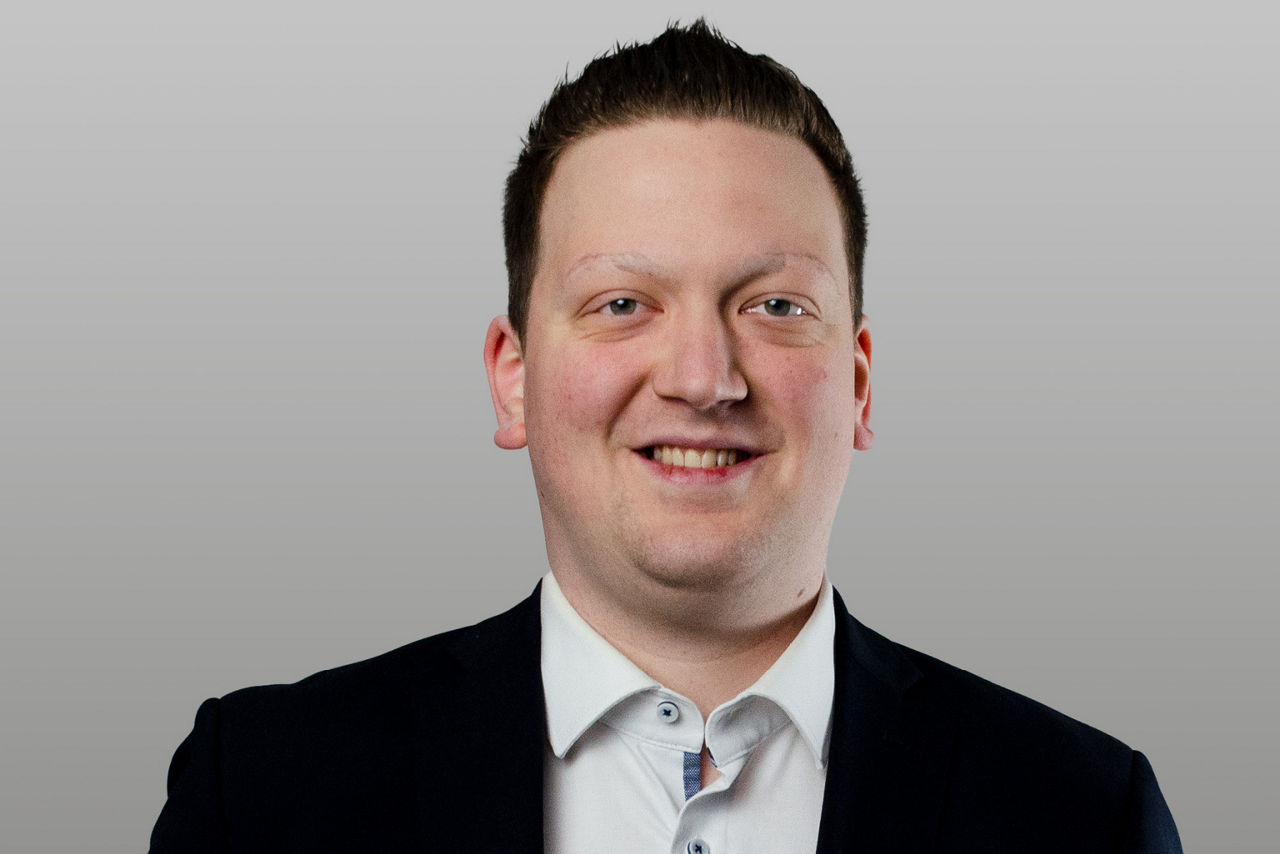 Privatkundenberater Arne Schulte vor grauen Hintergrund