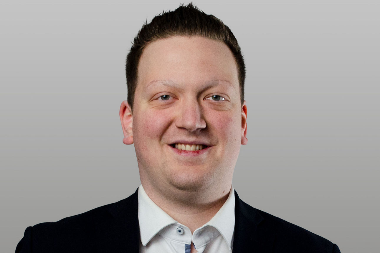 Privatkundenberater Arne Schulte vor grauen Hintergrund