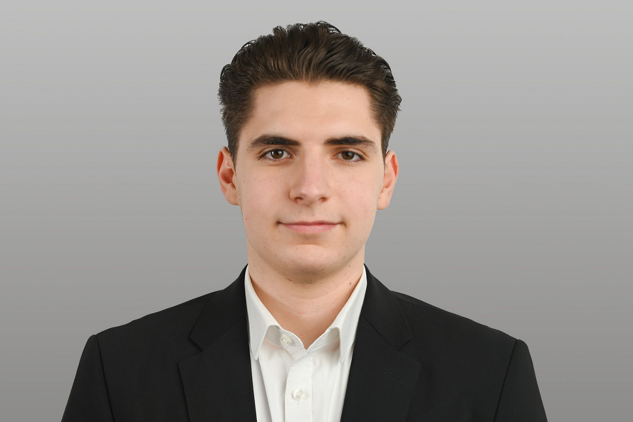 Kundenberater Dion Schulte vor grauen Hintergrund
