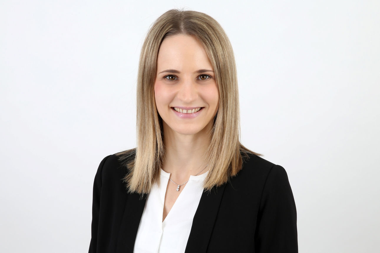 Eine lächelnde Frau schaut in die Kamera.