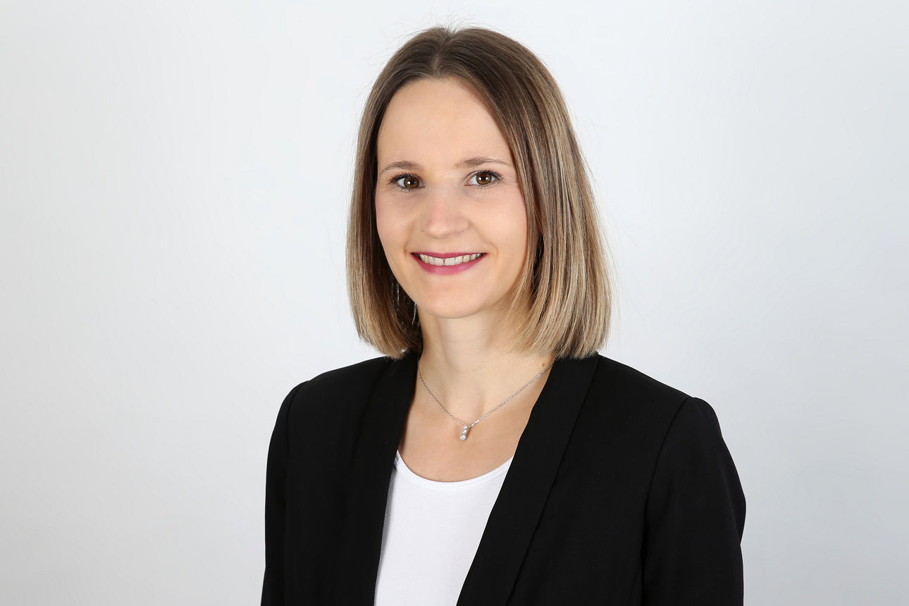 Eine lächelnde Frau schaut in die Kamera.