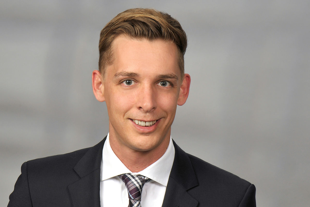 Benjamin Schwarz hat blonde Haare und trägt einen Anzug mit Krawatte