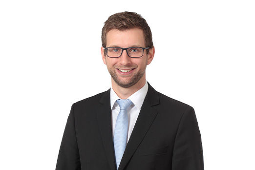 Freundlich lächelnder Mann im Anzug, unser Firmenkundenberater Sebastian Schweiger