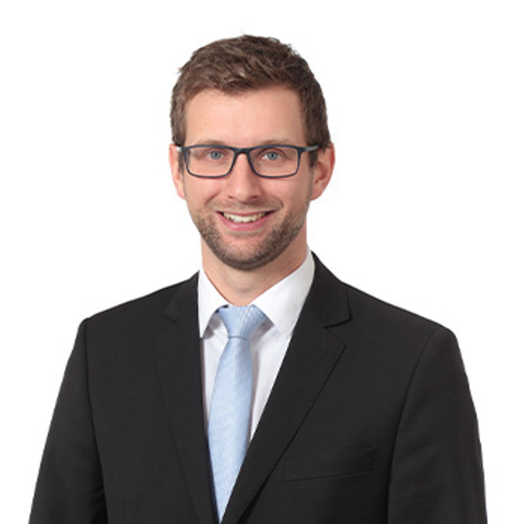 Freundlich lächelnder Mann im Anzug, unser Firmenkundenberater Sebastian Schweiger