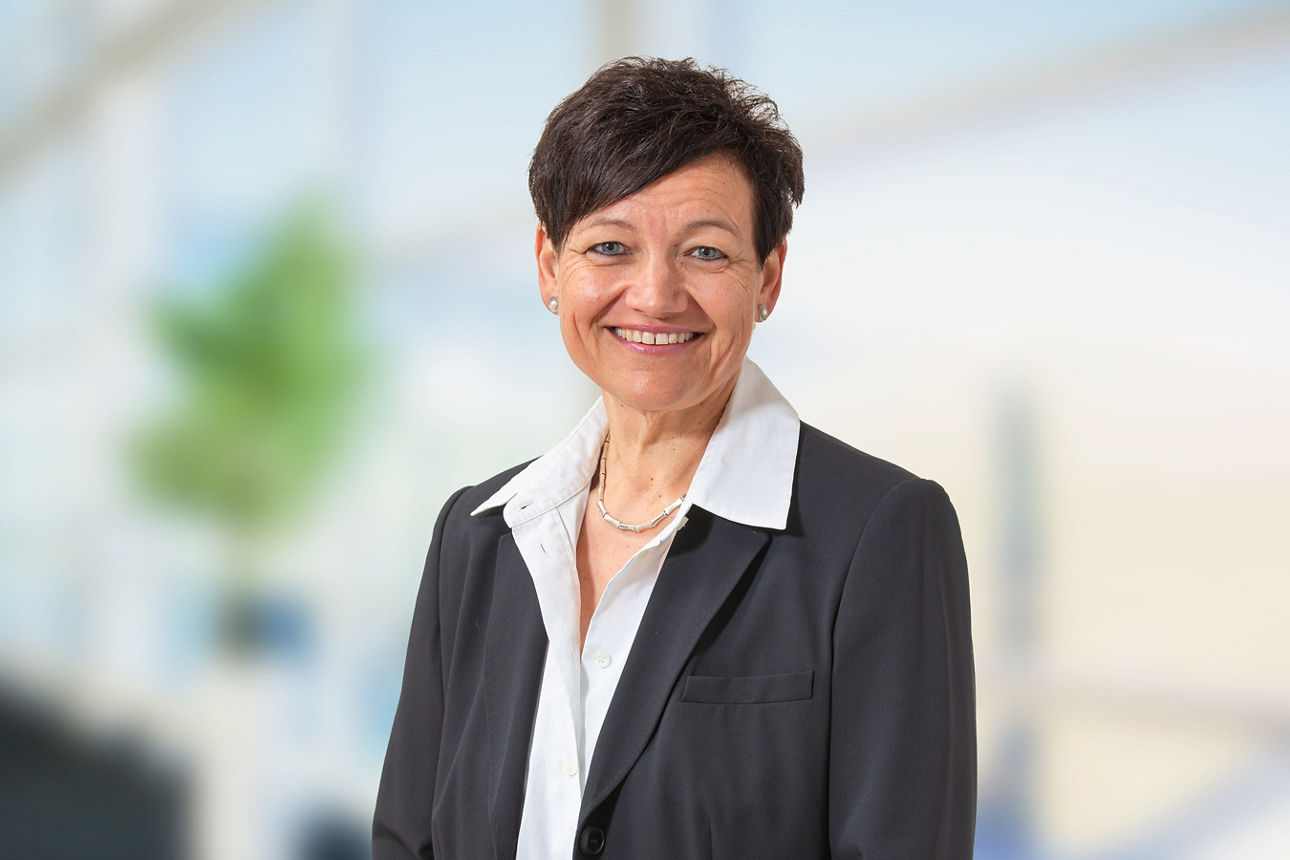 Personalreferentin Ilona Seidler im schwarzen Blazer mit weißer Bluse vor einen hellen Hintergrund