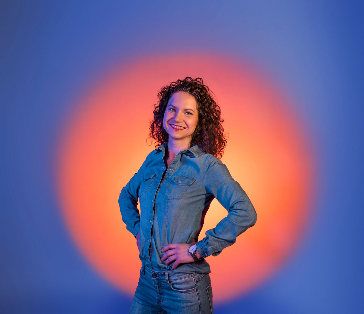 Eine junge Frau steht vor blauem Hintergrund