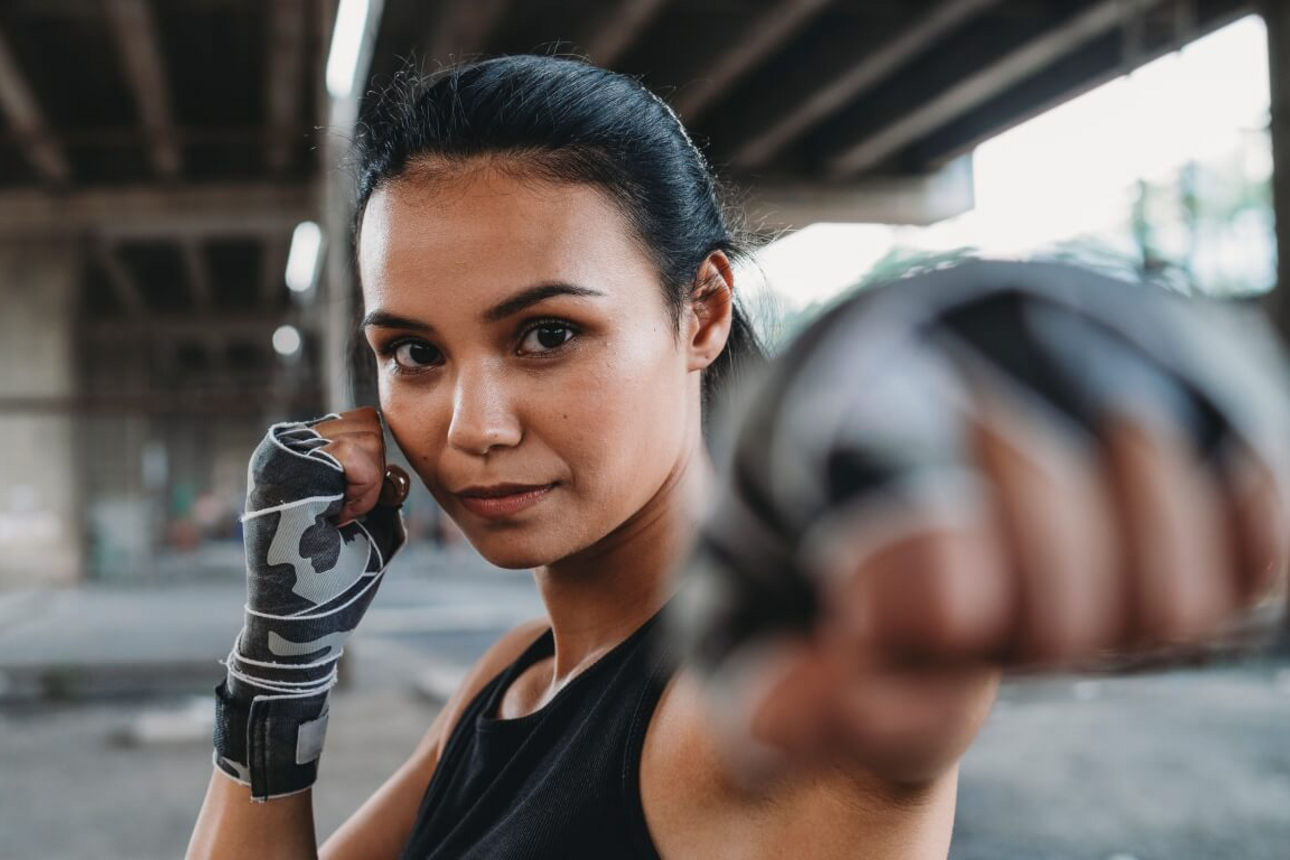 Frau macht eine Boxpose in die Kamera