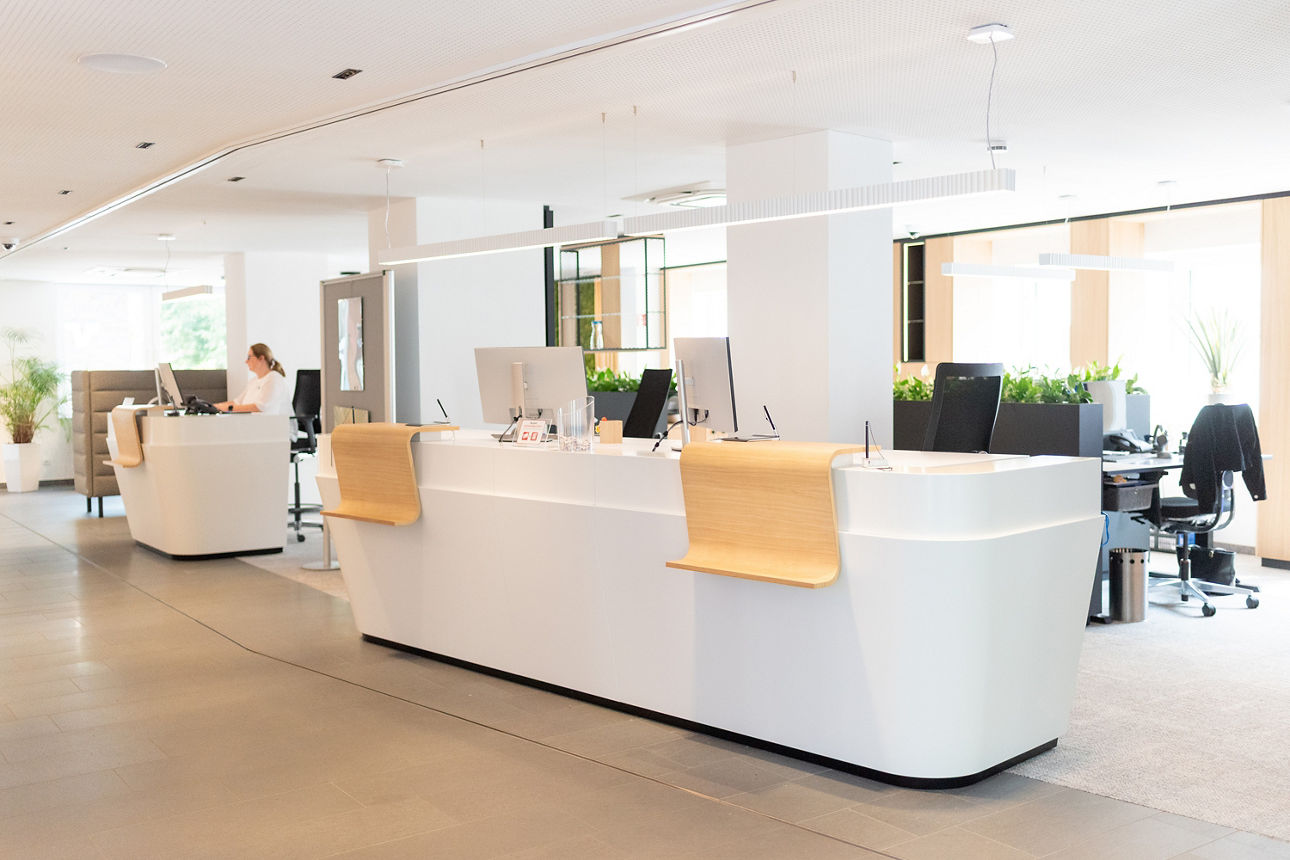 Unser Service - unsere weißen Zweier-Schalterplätze  mit der Holzablage in unserer offenen Schalterhalle