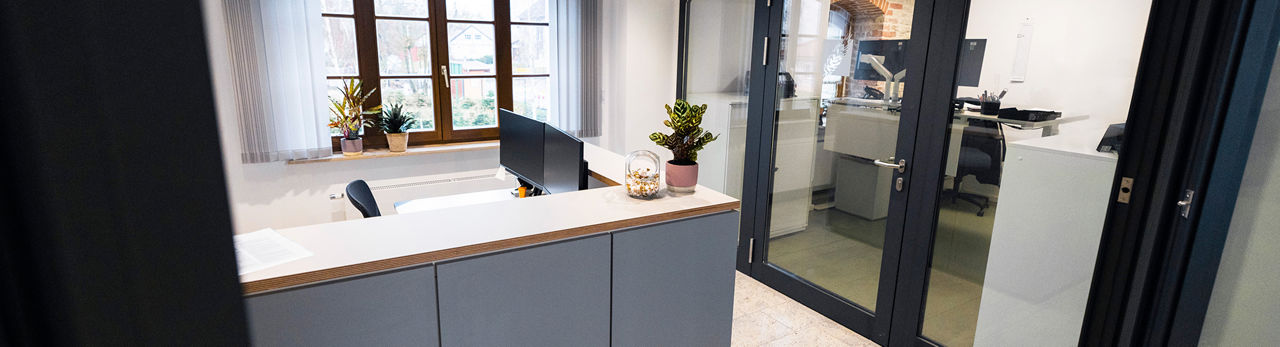 Leeres Bürozimmer mit Tisch, Stuhl, und Monitoren 