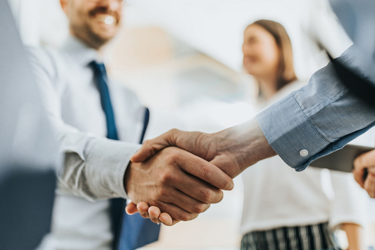 Haendeschütteln im Hintergund ist eine Frau zusehen