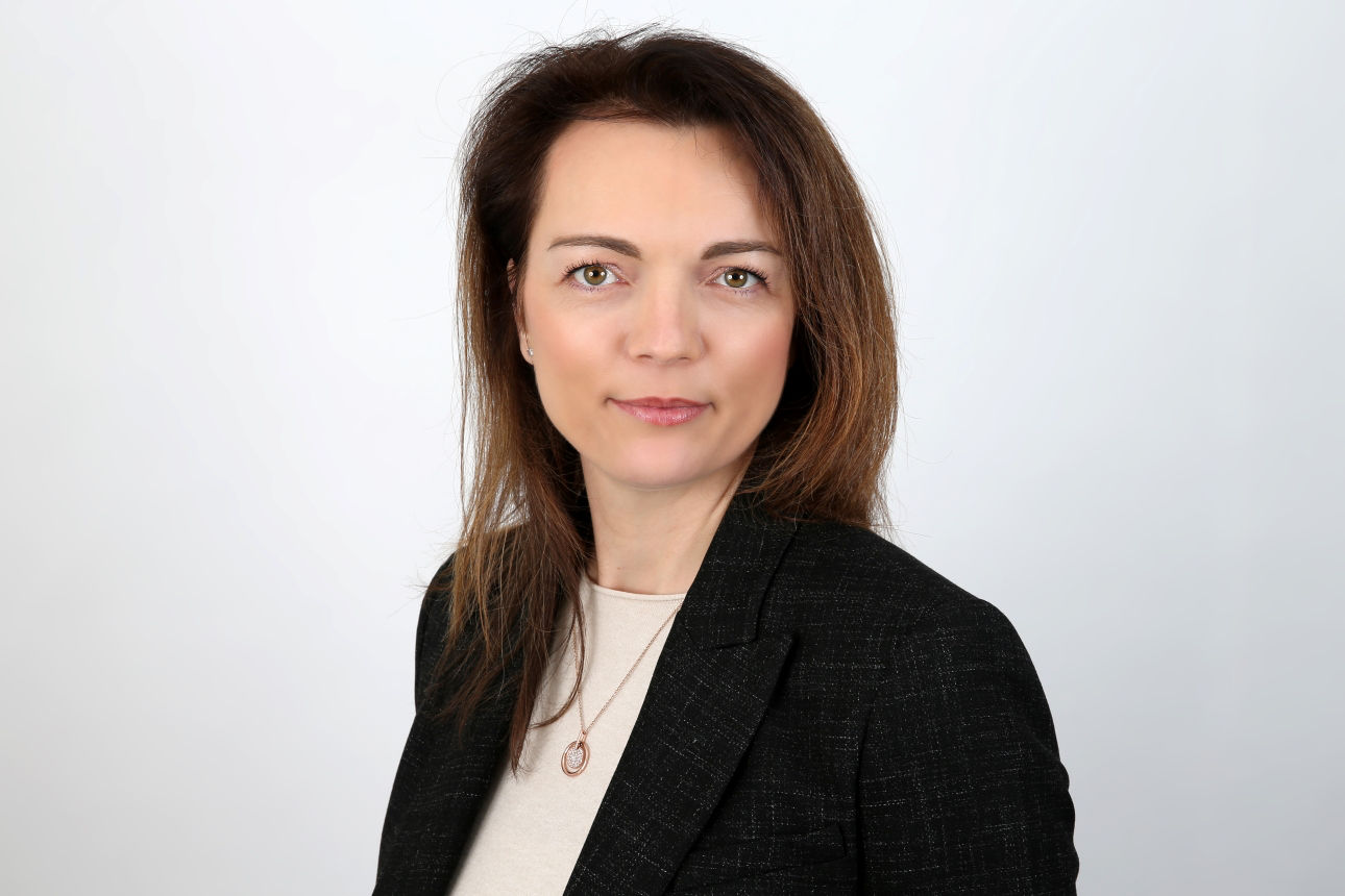 Eine lächelnde Frau schaut in die Kamera.