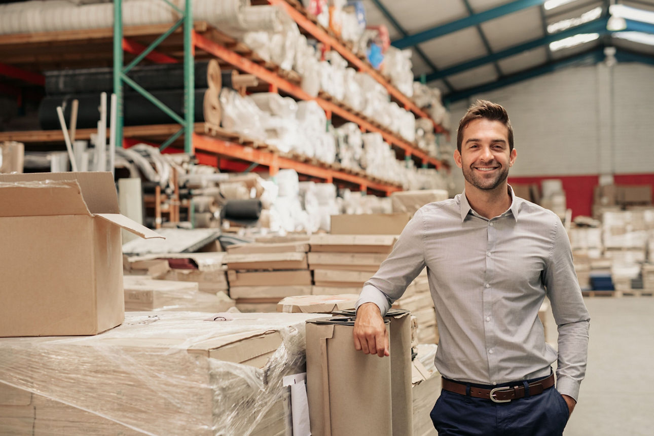 Ein Geschäftsmann steht in einer Lagerhalle