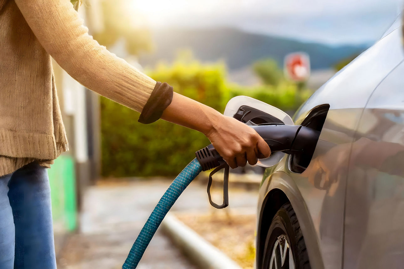 Frau lädt ihr E-Auto auf