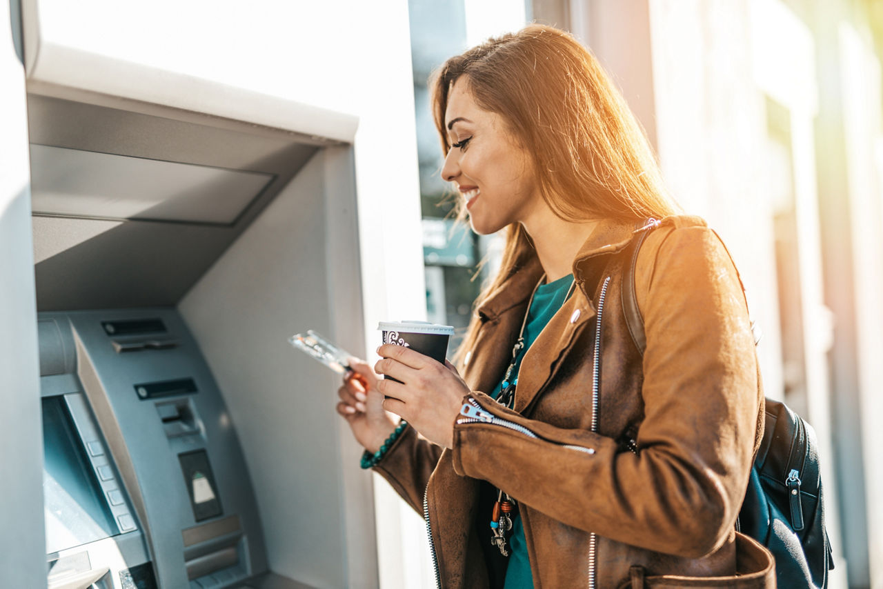 Frau hebt Geld am Geldautomaten ab