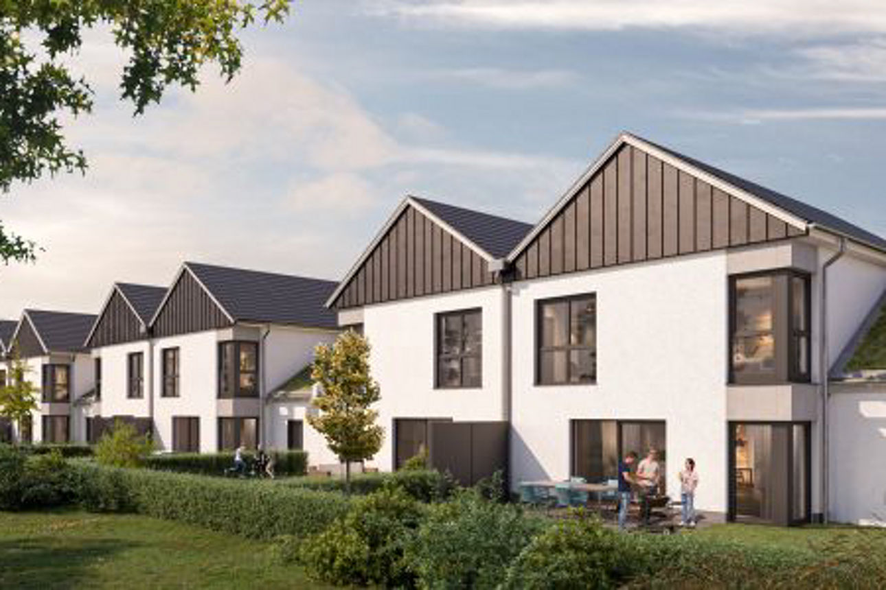 Moderne Doppelhäuser mit Satteldächern in einer grünen Umgebung, Gärten und Bäumen. Im Vordergrund unterhalten sich Personen.
