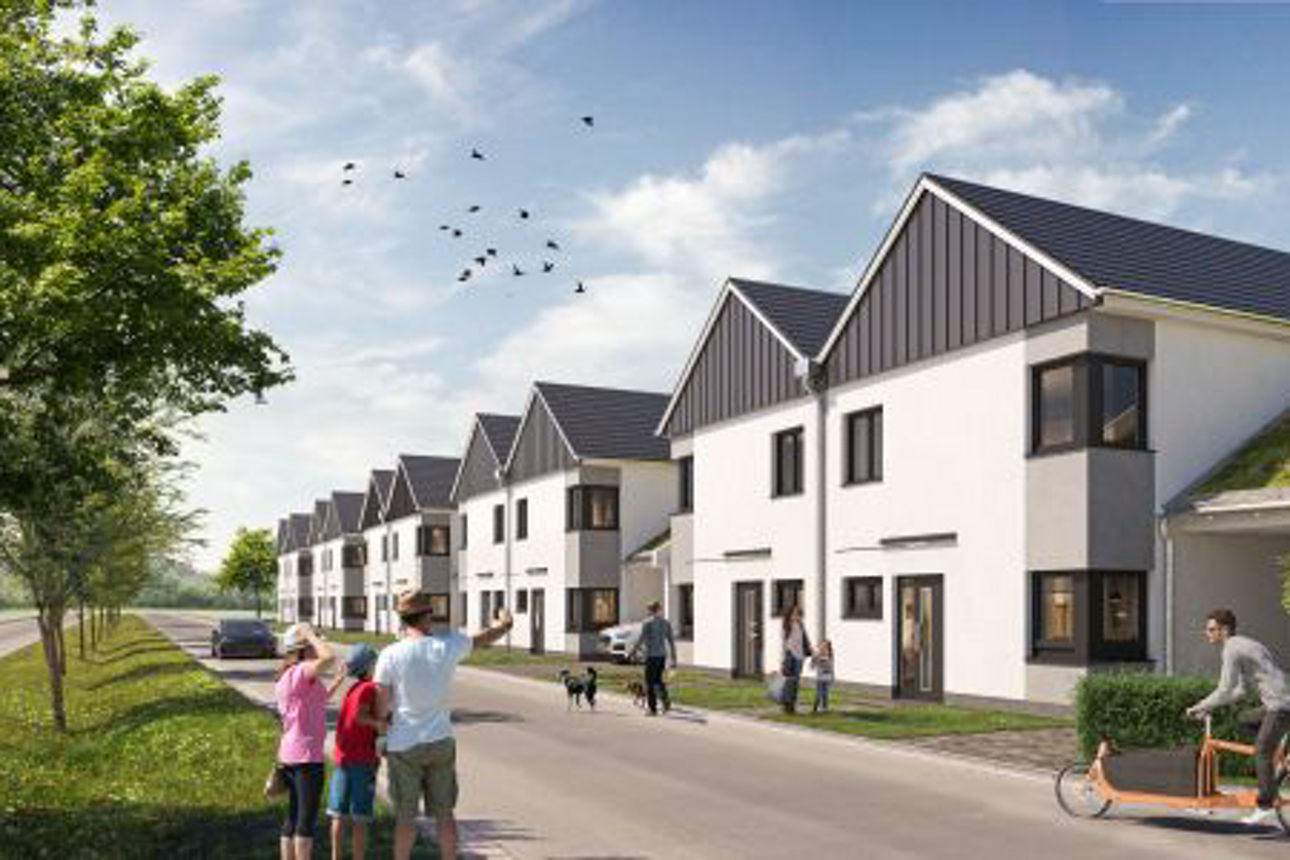 Reihe moderner Doppelhäuser mit Satteldächern an einer ruhigen Straße, gesäumt von Bäumen.